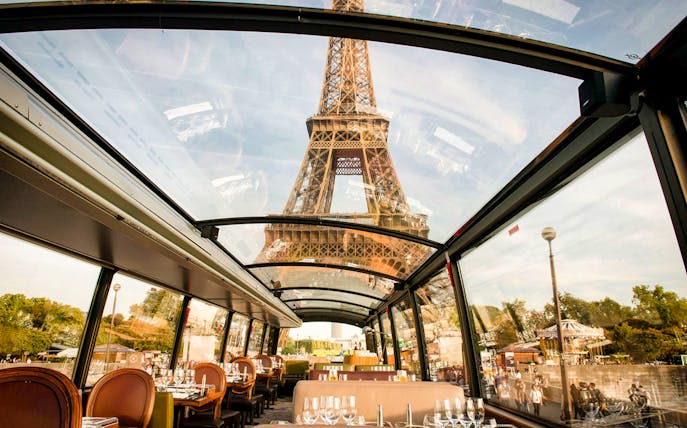 Interior view of La Marina Orsay lunch cruise with Eiffel Tower through glass ceiling, Paris.