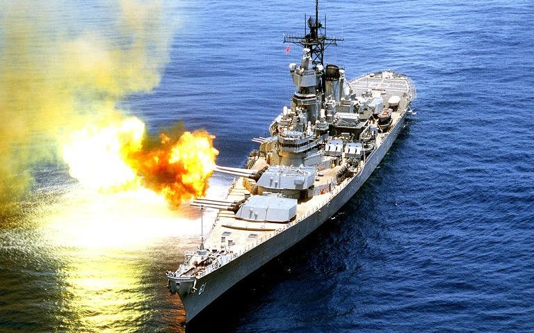 Battleship firing cannon on open sea near Los Angeles.