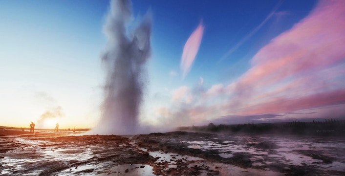 Geyser erupting at sunset on Iceland's Golden Circle Tour.