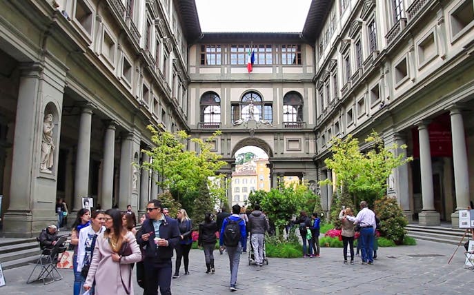 Visitors walking through the courtyard of the Uffizi Gallery in Florence.