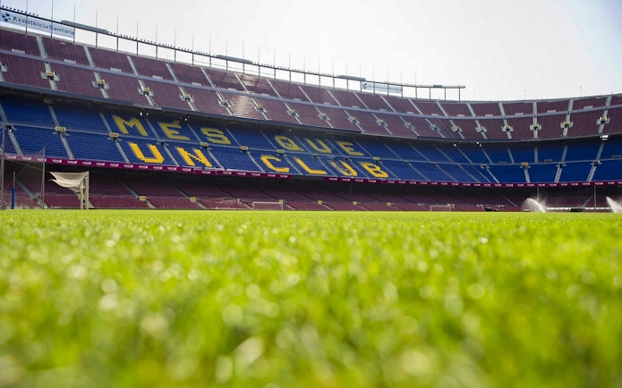 Camp Nou stadium field with "Més Que Un Club" seats, Barcelona.