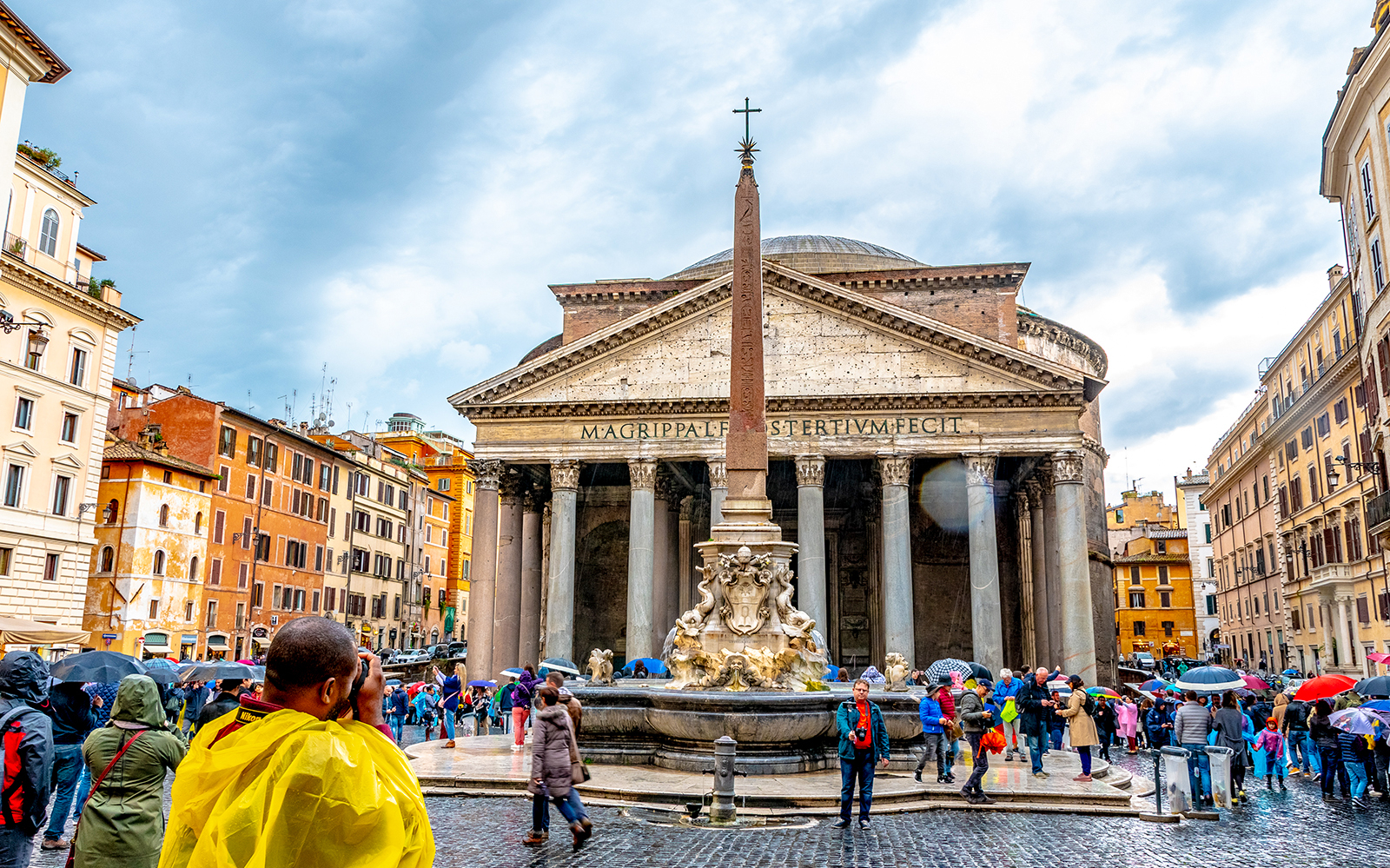 Pantheon in Rome with tourists and fountain in foreground.
