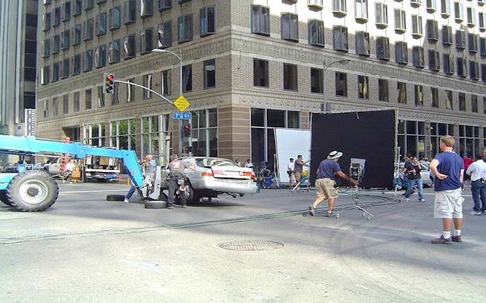 Film crew setting up a scene on a city street corner for a movie location tour.