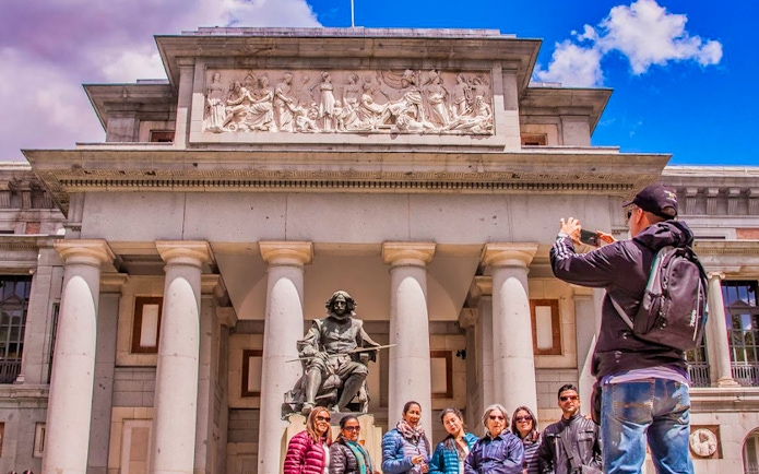 Tour group outside Madrid's Prado Museum with Velázquez statue.