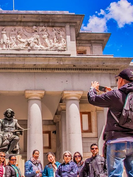 Tour group outside Madrid's Prado Museum with Velázquez statue.
