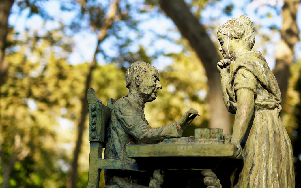 Statue of two figures playing chess in El Retiro Park, Madrid.