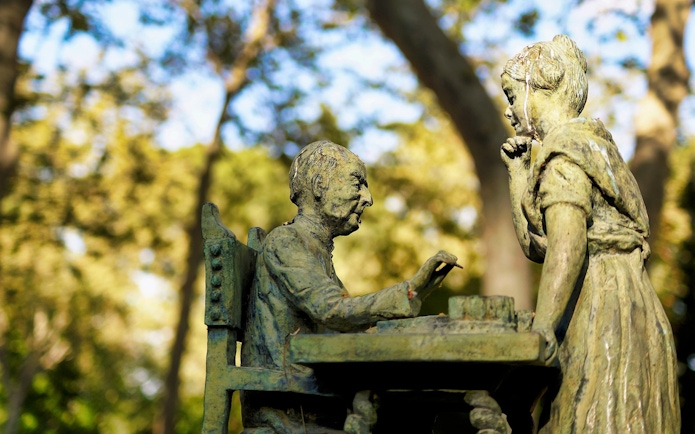 Statue of two figures playing chess in El Retiro Park, Madrid.