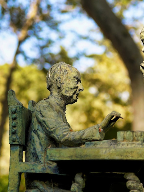 Statue of two figures playing chess in El Retiro Park, Madrid.