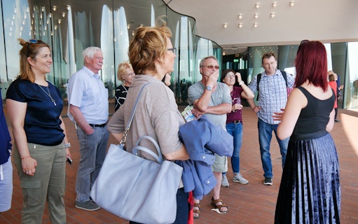 Group listening to a guide at Elbphilharmonie during Hamburg harbor tour.