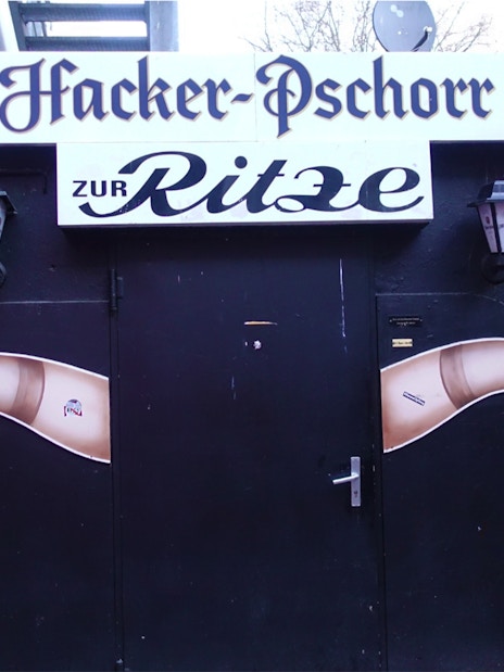 Entrance to Zur Ritze bar in Hamburg's Reeperbahn, featuring iconic leg artwork.