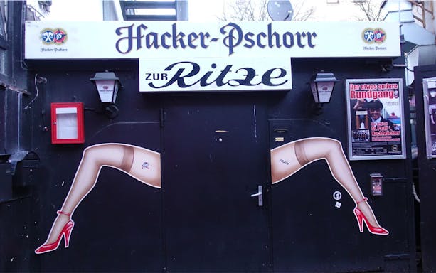 Entrance to Zur Ritze bar in Hamburg's Reeperbahn, featuring iconic leg artwork.