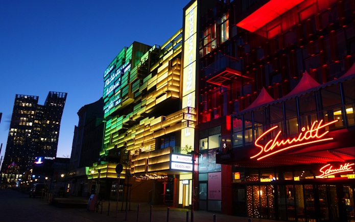 Colorful neon lights on buildings in Hamburg's Reeperbahn district at night.