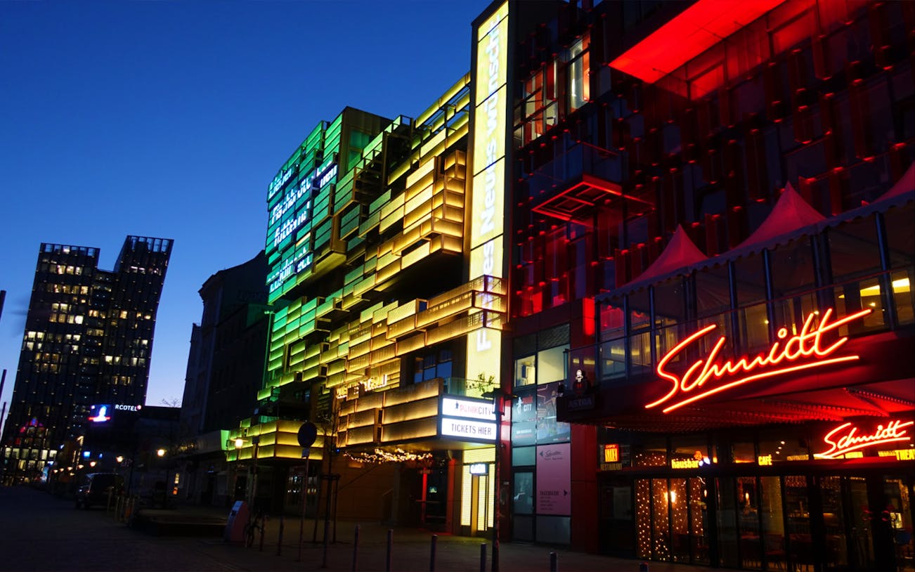 Colorful neon lights on buildings in Hamburg's Reeperbahn district at night.