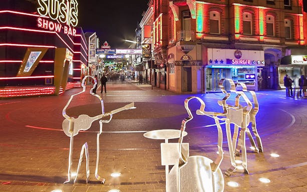 Sculptures of musicians on Reeperbahn street, Hamburg, during a night walking tour.