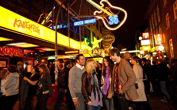 Group enjoying nightlife on Reeperbahn street, St. Pauli, Hamburg.