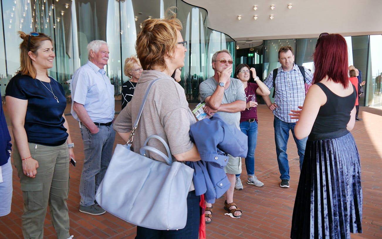 Tour group listening to a guide at Hamburg's Elbphilharmonie during the Great Harbor Cruise.