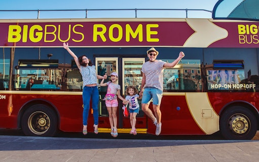 Family jumping in front of a Big Bus Rome tour bus, enjoying a hop-on hop-off experience.