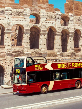 Open-top tour bus in front of the Colosseum, Rome.