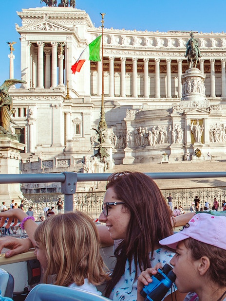 Tourists on a hop-on hop-off bus viewing the Altare della Patria in Rome.