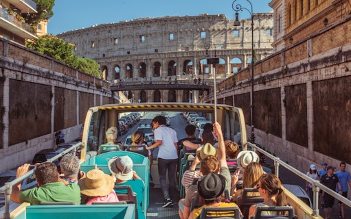 Open-top bus tour near the Colosseum in Rome, Italy.