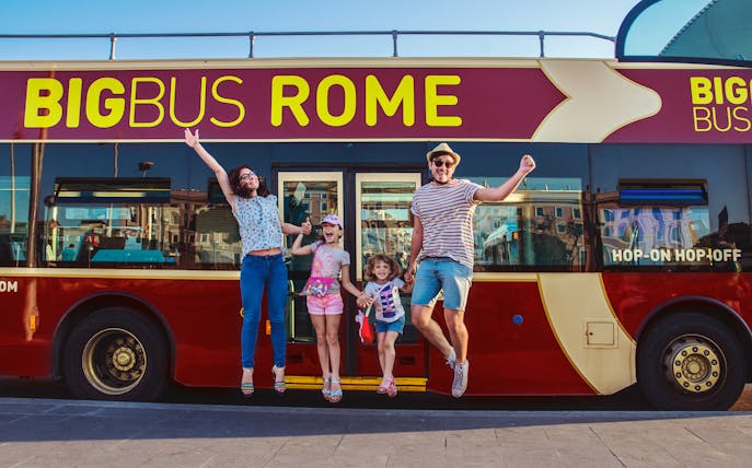 Family jumping in front of Big Bus Rome for 3-day hop-on hop-off tour with walking tours.