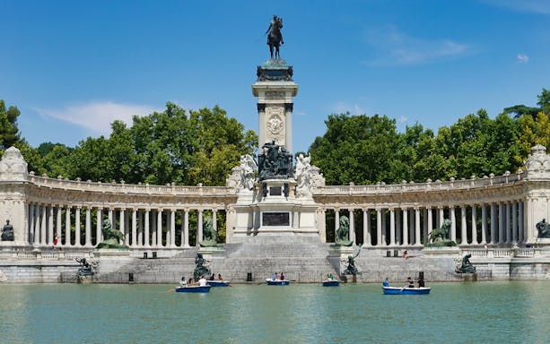 Boats on the lake in front of the Alfonso XII monument in El Retiro Park, Madrid.