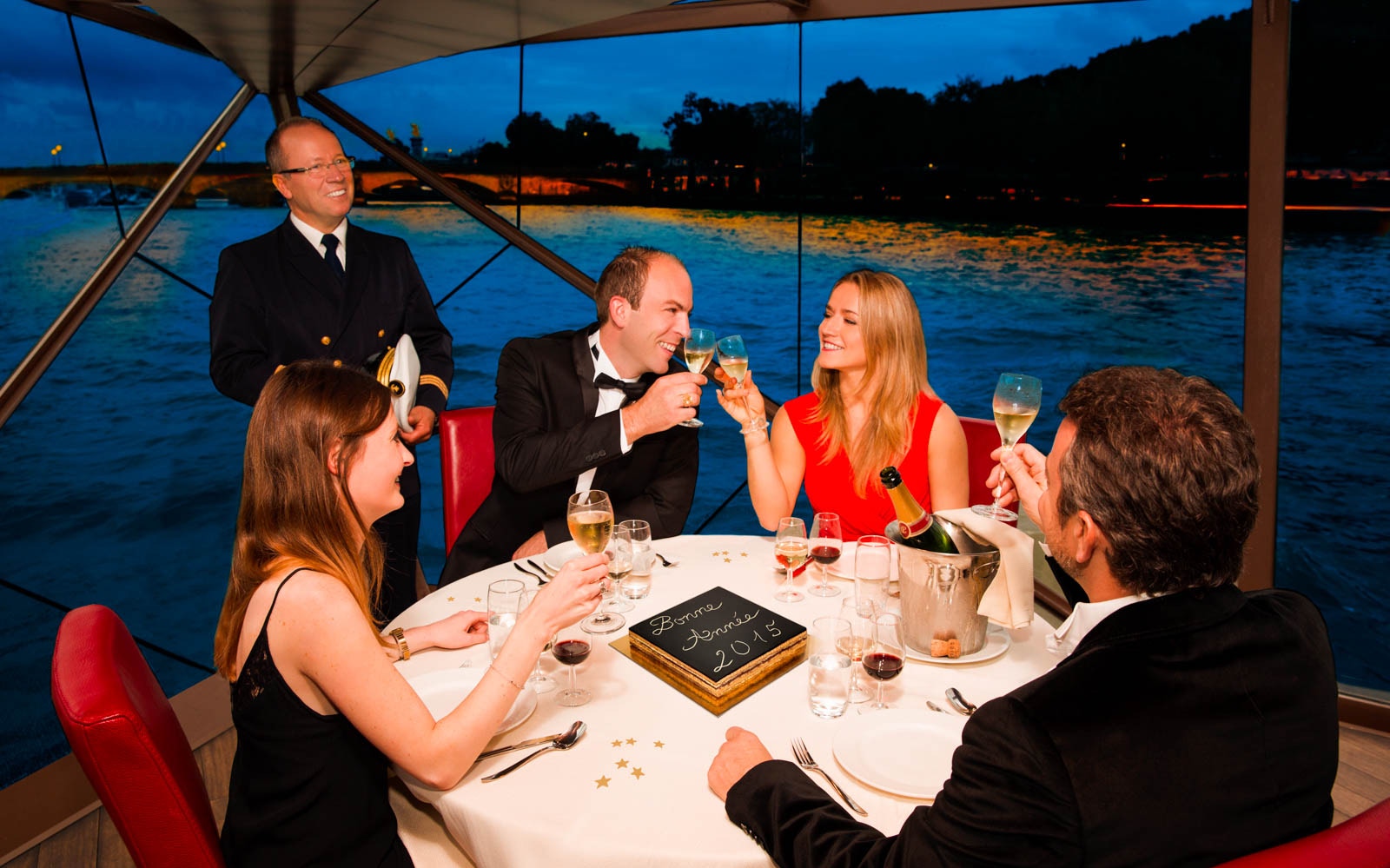 All kinds of people cheering and enjoying their dinner cruise on the boat.