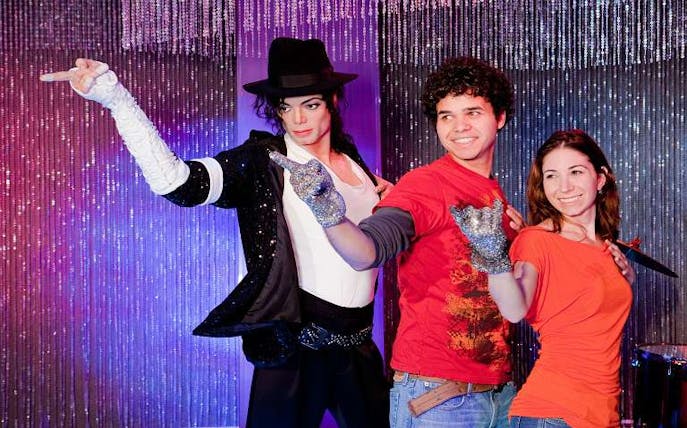 Visitors posing with a wax figure at a Hollywood attraction