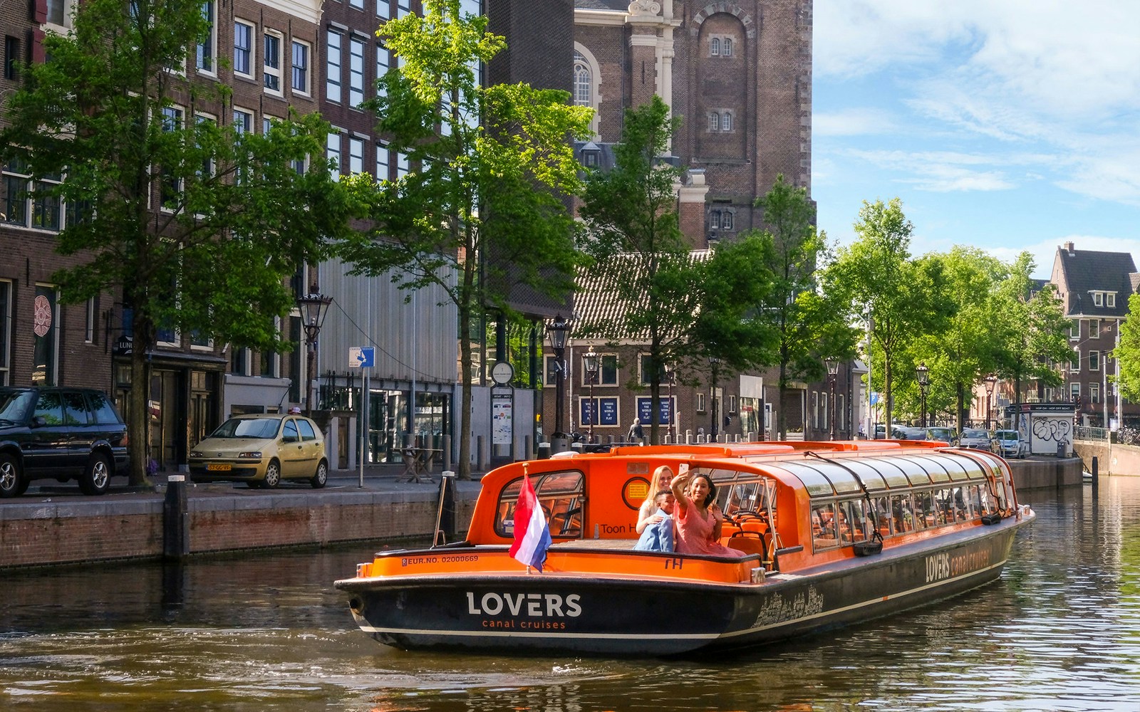 Amsterdam canal with tour boat during one-hour sightseeing cruise.