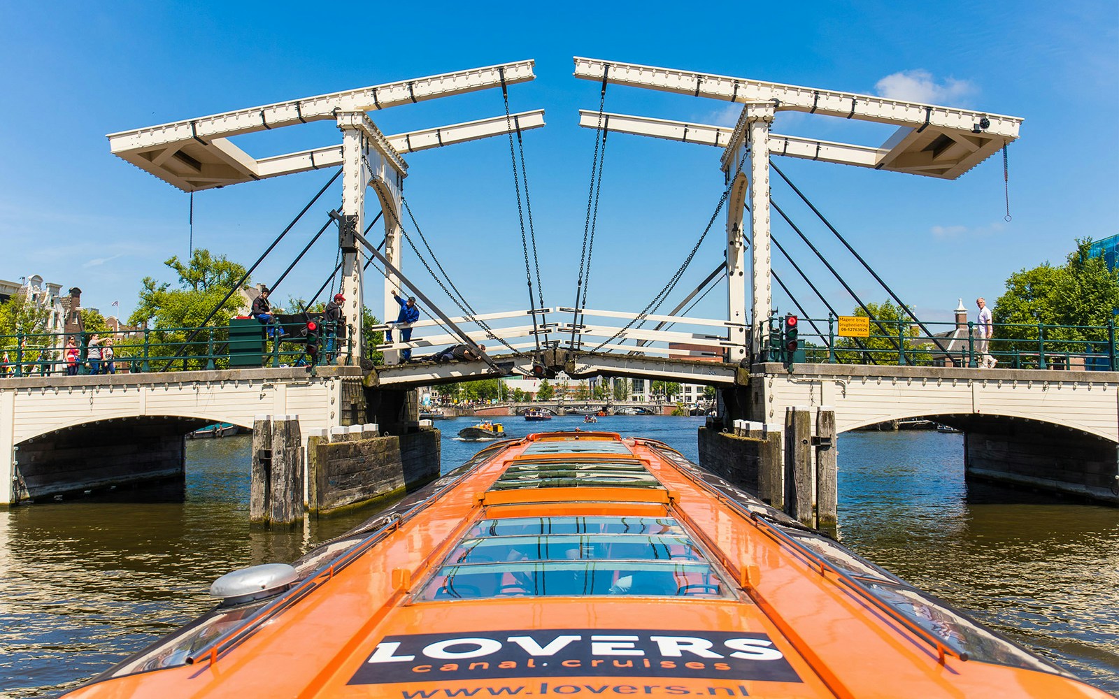 Cruise boat passing under the Skinny Bridge in Amsterdam.
