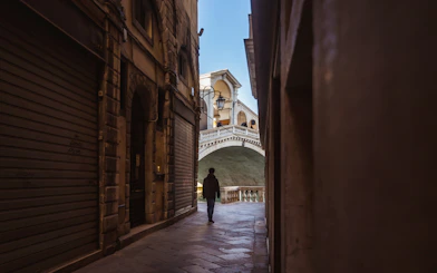 Walking through a narrow alley towards the Rialto Bridge in Venice.
