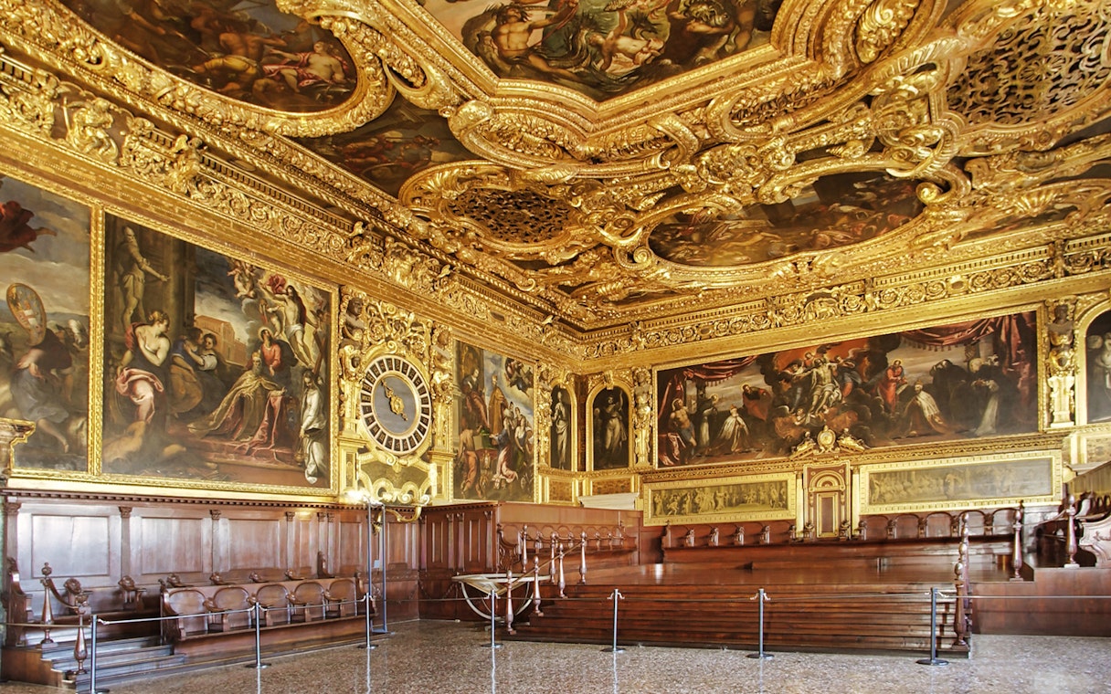 Doge's Palace ornate hall with gilded ceiling and historic paintings, Venice, Italy.