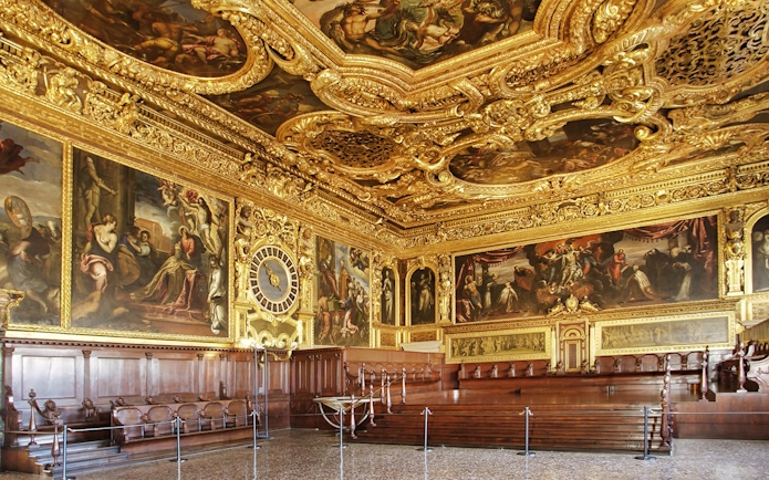 Doge's Palace ornate hall with gilded ceiling and historic paintings, Venice, Italy.