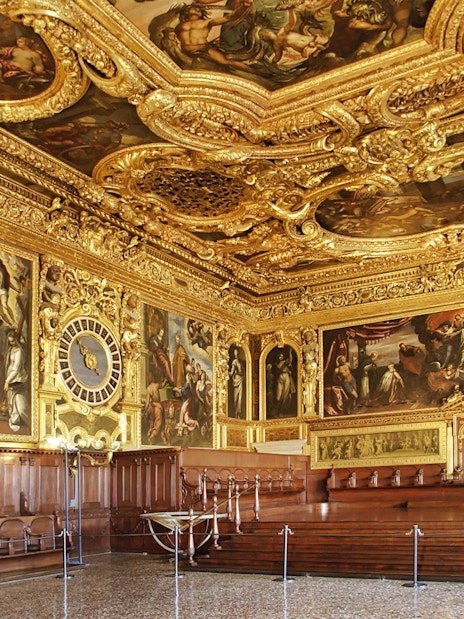 Doge's Palace ornate hall with gilded ceiling and historic paintings, Venice, Italy.