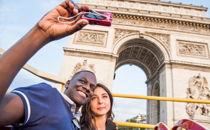 Tourists enjoying the Big Bus Paris Hop-On Hop-Off Bus Tour with a view of the Eiffel Tower and Seine River in the background