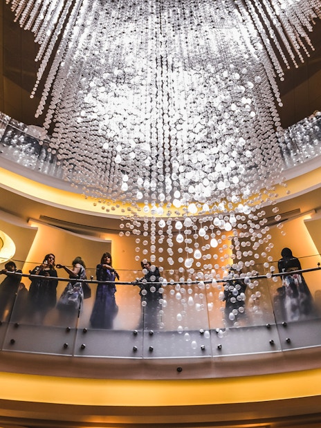 Visitors admire the grand chandelier inside Dubai Opera House.
