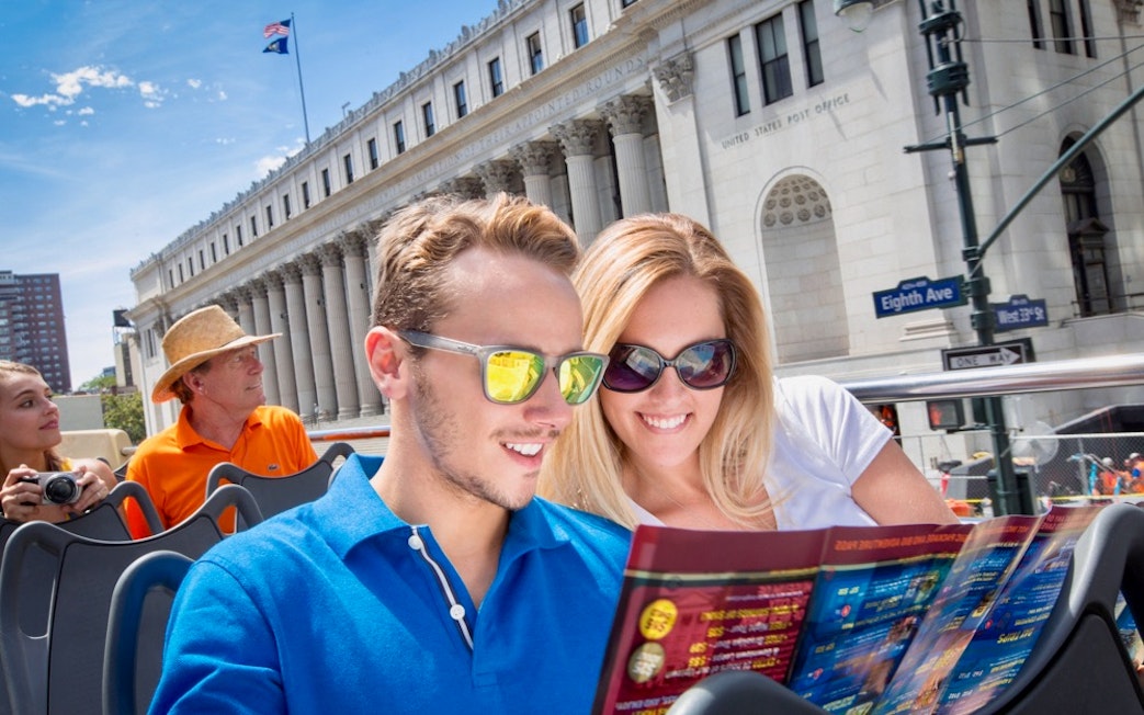 Open-top bus tour in New York City with passengers viewing a map near the U.S. Post Office on Eighth Ave.