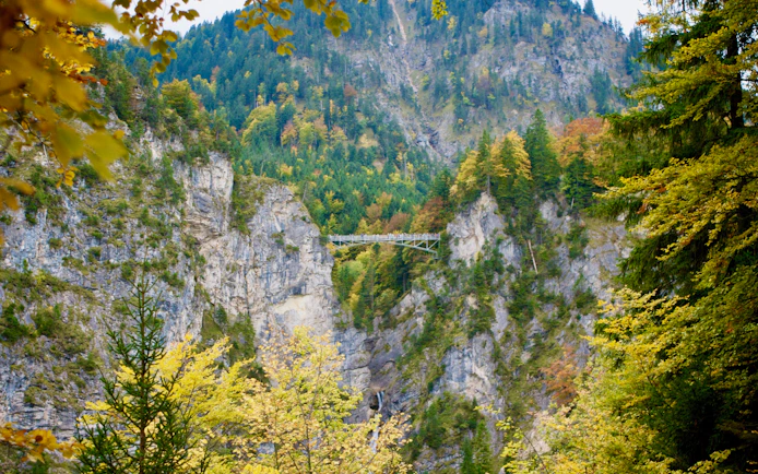 Bridge over rocky gorge surrounded by forest near Neuschwanstein, seen on Munich coach tour.