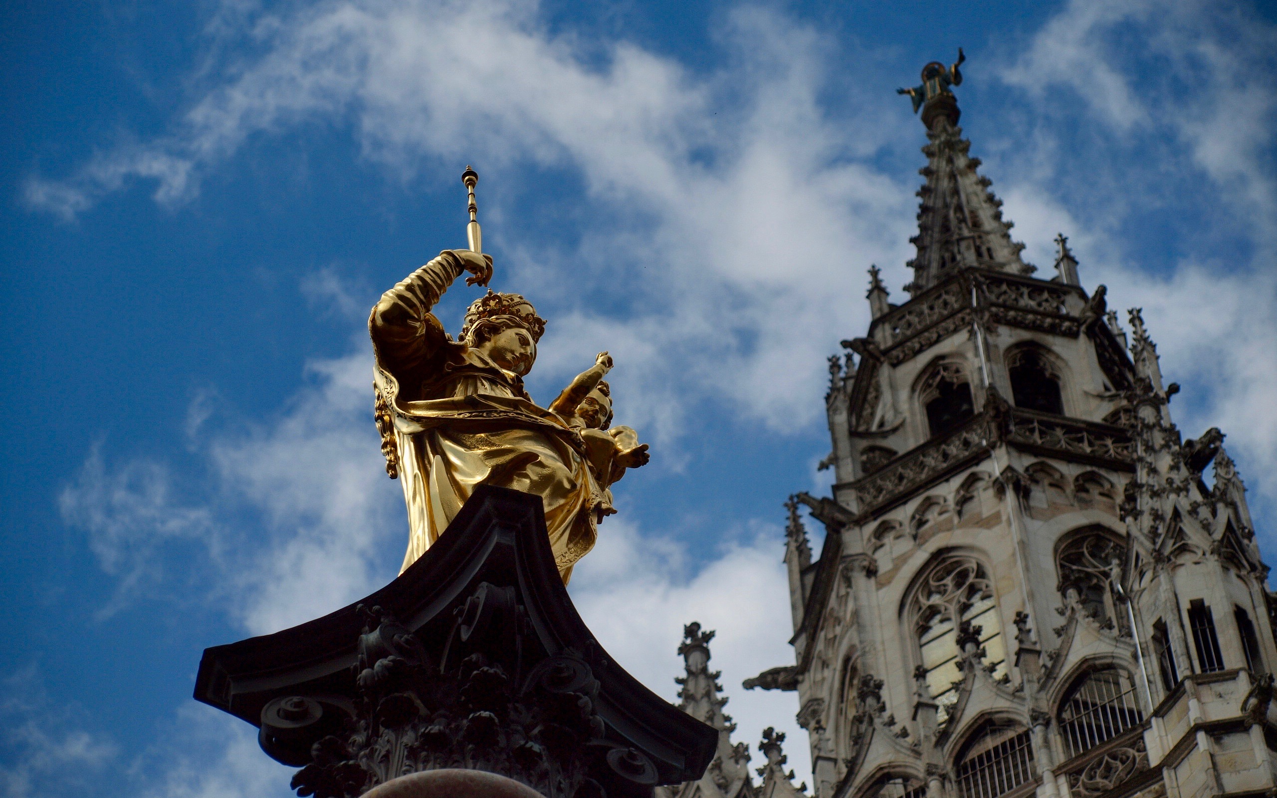 Golden statue and church spire in Munich on Neuschwanstein, Oberammergau & Linderhof tour.