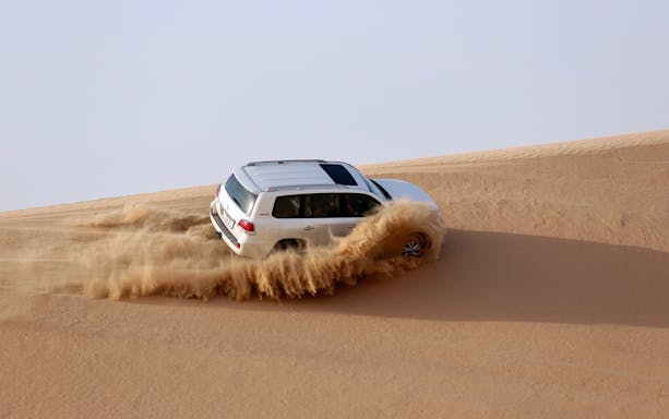 Dubai desert safari with camel ride and dinner under the stars.