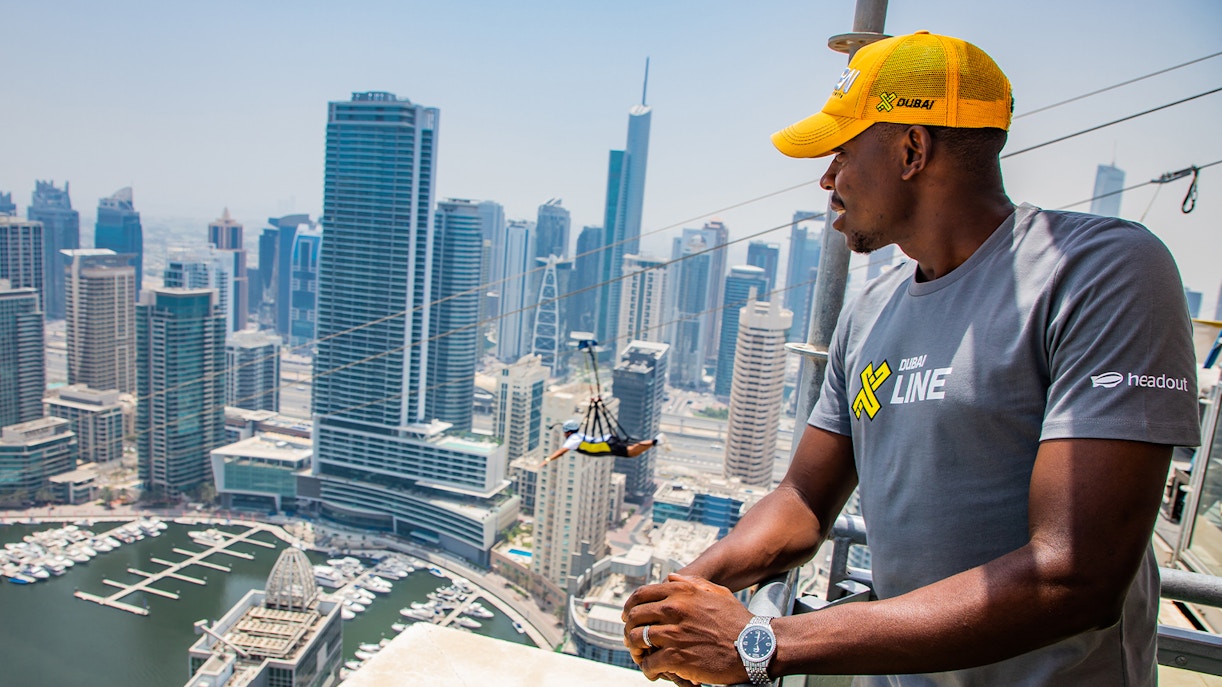 Thrill-seeker ziplining over Dubai Marina with skyscrapers and waterfront views.