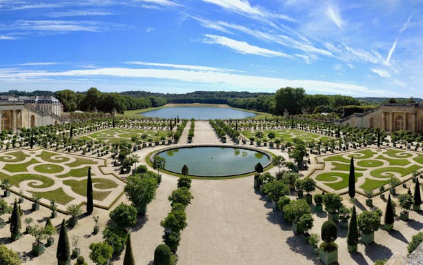 Guided tour group exploring the Hall of Mirrors in the Palace of Versailles, France.