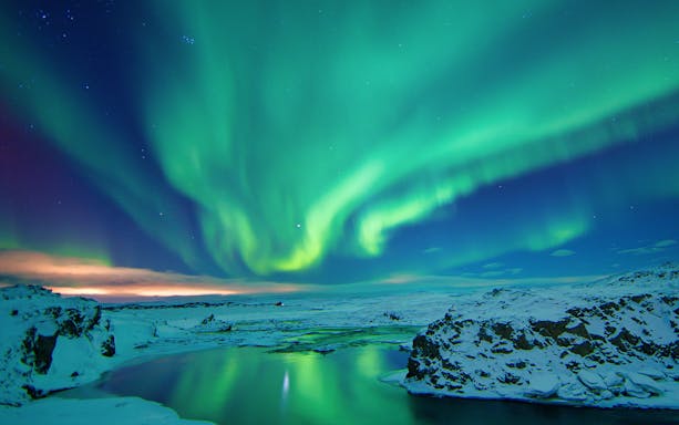 Northern Lights over snowy landscape near Reykjavik, Iceland.