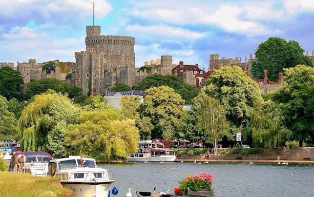 Windsor Castle view with boats on the River Thames, part of a guided tour from London.