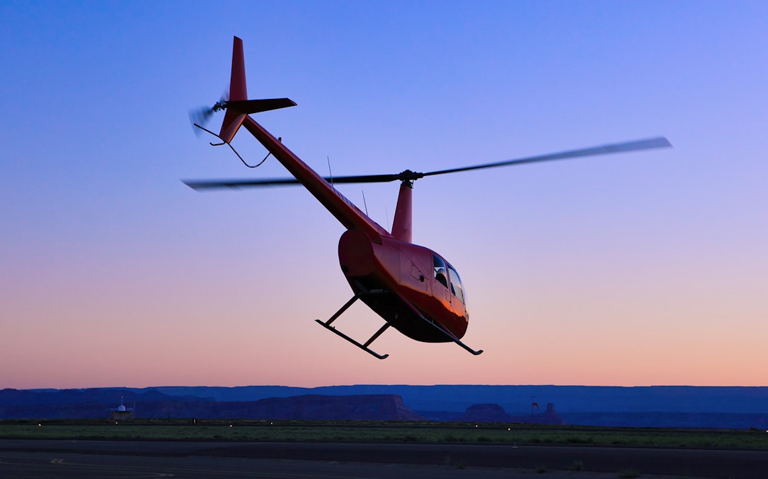 Helicopter taking off at sunset for a couple's private 45-minute tour.