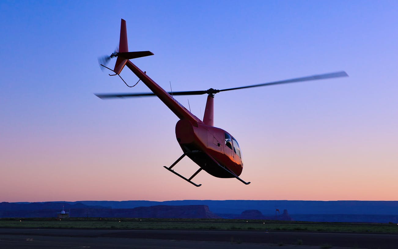 Helicopter taking off at sunset for a couple's private 45-minute tour.