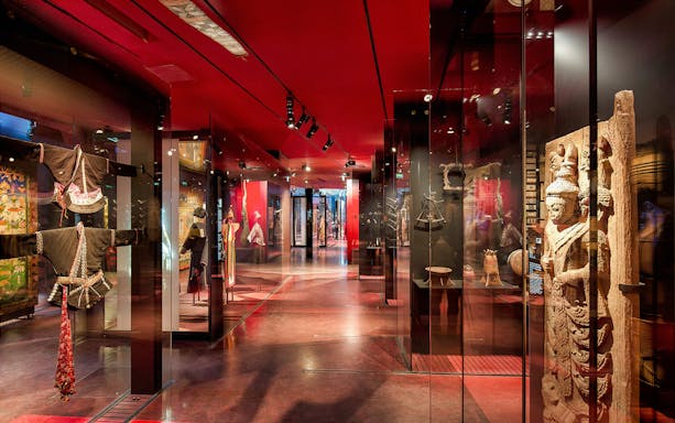 Quai Branly Museum interior with cultural artifacts and traditional garments on display.
