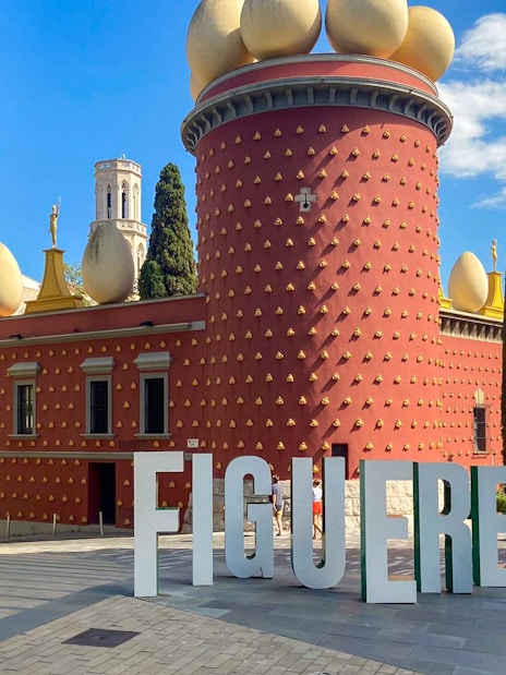 Figueres Dali Museum exterior with large egg sculptures and nearby statue.