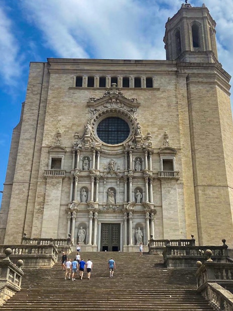Girona Cathedral facade with tourists on steps, part of Girona & Figueres day trip from Barcelona.