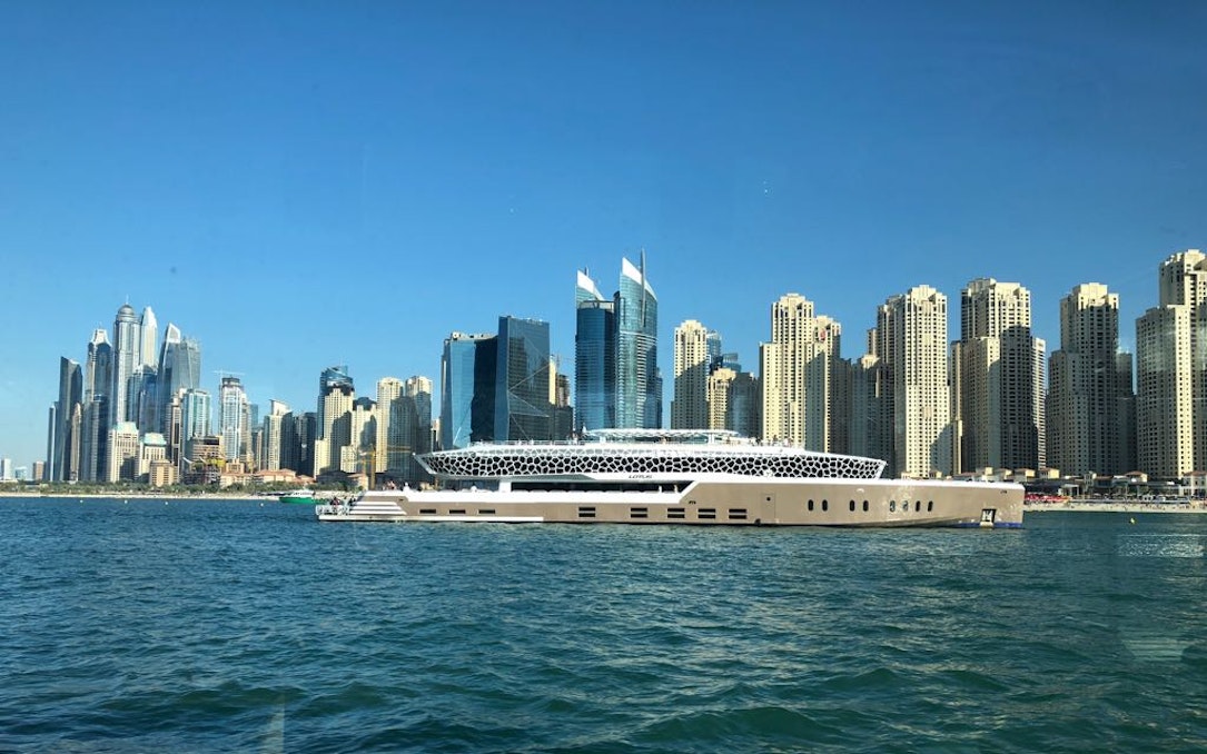 Lotus Mega Yacht cruising near Dubai Marina skyline.
